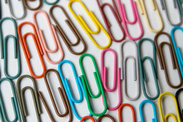 Many colorful paper clips on a home office desk for stationary design as colorful pattern to tidy desk, papers and paperwork to attach attachments to files and documents or collection of office supply