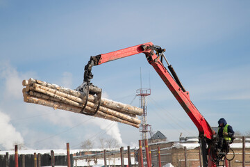 Loading logs on a logging truck. Wood loader. Woodworking industry.