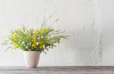 bouquet of wild flowers on background white wall