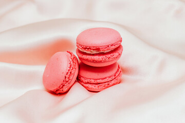 French pink macaroon cookies on silk tablecloth.