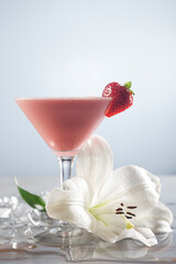Velvet Socks cocktail mixed with tequila, milk, grenadine, ice and garnished with strawberry and a large white flower.