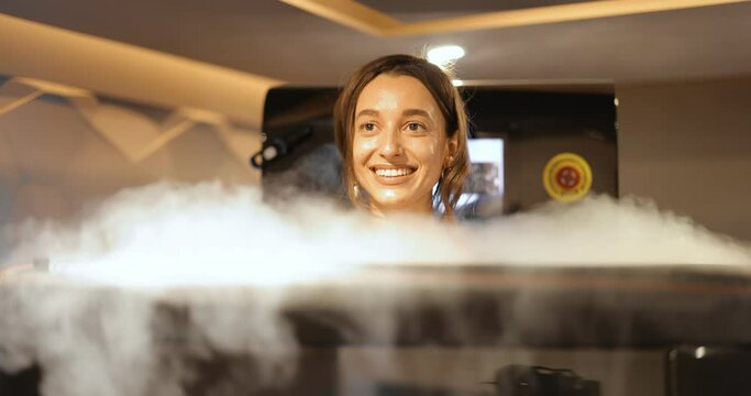 Young woman during cryotherapy in a special capsule. Wellness in a medical spa. Cryo sauna