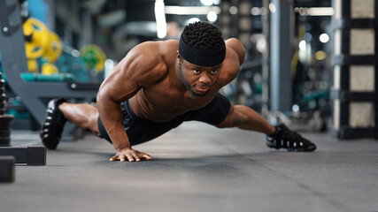 Fototapeta na wymiar Motivated black guy bodybuilder doing some push-ups