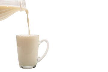 Milk is being poured from a bottle into a cup.