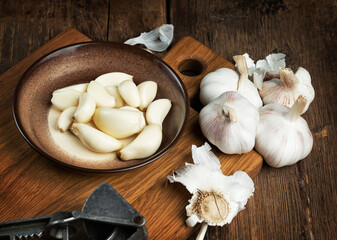 heads of garlic close-up on a kitchen board on a wooden table.