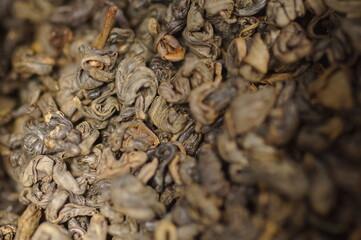 Dried green tea leaves. Preparing a hot drink. Several servings of tea in a zoomed-in view. Tea in a metal tin.