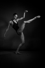 Fototapeta na wymiar black and white dramatic vintage portrait of a girl, dancing ballerina in a black bodysuit in the Studio on gray background