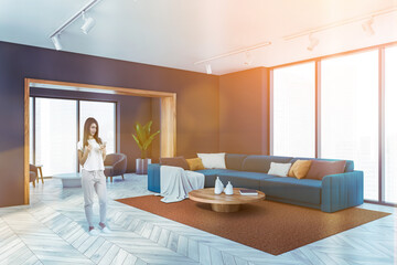 Young woman in casual clothes in luxury living room with blue sofa