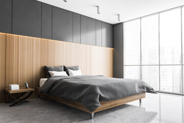 Bed and linens in grey and wooden bedroom with window