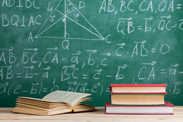 Education concept - books on the desk in the auditorium