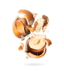 Two crushed hazelnuts in air close up, isolated on white background