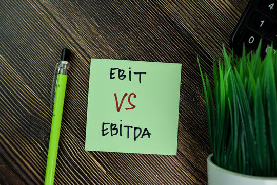 Ebit Vs Ebitda write on sticky notes isolated on Wooden Table.