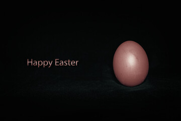 A bronze colored egg on a dark gray background. Caption: 