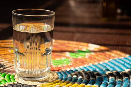 A Glass Of Water On A Palestine Home Made Rounded Straw 