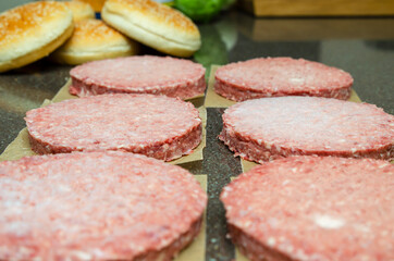 Frozen burger meat on table before grilling, defrost before grilling