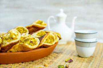 Ramadan sweets qatayef with white background and arabian coffee cups