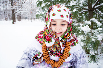 Child wrapped in a scarf in winter at the Pine, with bagels around the neck