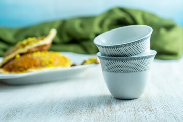 Ramadan sweets qatayef with white background and arabian coffee cups