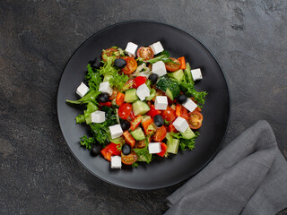Greek salad on black plate 