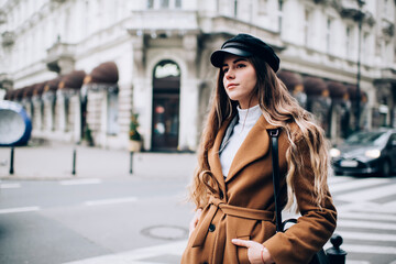 Fototapeta premium Stylish woman in coat standing on street
