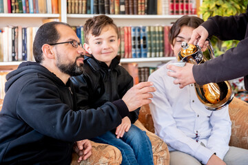 happy muslim Family served with arabic coffee during eid mubarak celebration