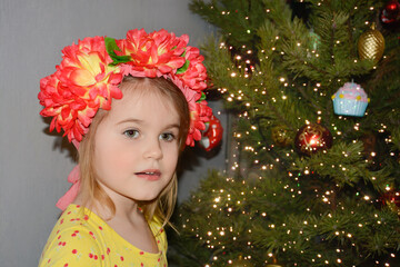 portrait of the girl in a wreath of flowers with christmas tree