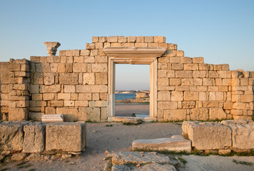 Ancient ruins at sunset on the beach .