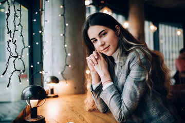 Glad woman resting in cozy cafe