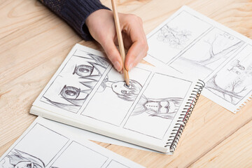 Artist drawing an anime comic book in a studio. - obrazy, fototapety, plakaty