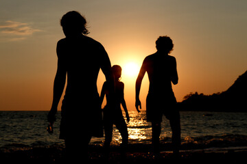 Fototapeta na wymiar silhouette of three person on the beach