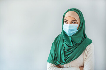 Muslim businesswoman wearing face mask during coronavirus epidemic and looking at the camera. Portrait of a Muslim woman wearing a facemask while looking at the camera, pandemic lifestyle concepts