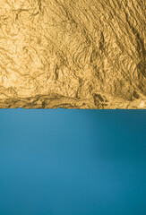 Gold texture. Rough structure mineral. Rock texture. Gold Ore. Gold rocks. Stone blue background.