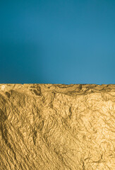 Gold texture. Rough structure mineral. Rock texture. Gold Ore. Gold rocks. Stone blue background.
