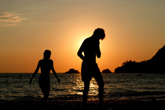 silhouette of a couple at sunset by the sea