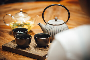 Selective focus shot of  people drinking hot tea on a wooden table, tea shop