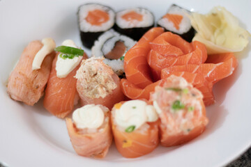 Close-up sushi and sashimi variety with ginger on a plate 