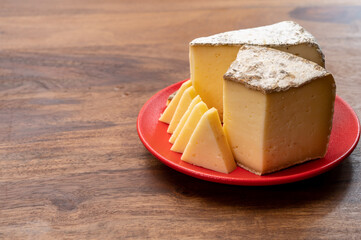 Cheese collection, Tomme de Savoie cheese from Savoy region in French Alps,  mild cow's milk cheese with beige interior and thick brownish-grey rind