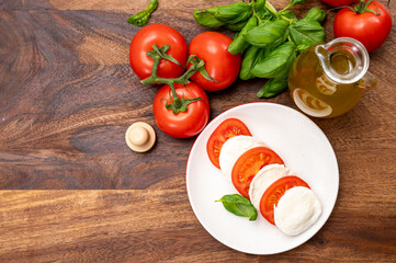 Tasty italian vegetarian food, fresh soft white mozzarella cheese served with red tomatoes and green basil