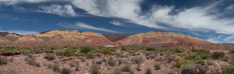 Travel. Panorama view of the arid desert and colorful mountains under a blue sky. 