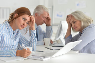 Obraz premium Portrait of tired businesspeople working in modern light office