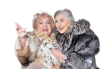 senior women in fur coats looking at something