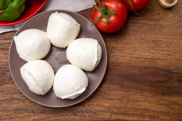 Cheese collection, small fresh white soft mozzarella cheese balls served with red tomatoes and fresh green basil from Italy