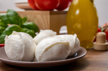 Cheese collection, small fresh white soft mozzarella cheese balls served with red tomatoes and fresh green basil from Italy