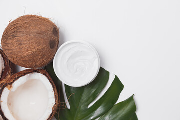 Natural coco cosmetic moisturizer cream on monstera palm leaf. SPA natural organic beauty product, skincare concept. Flat lay, top view