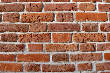 The texture of an old brick wall of red stone. Beautiful background of old masonry historic building.