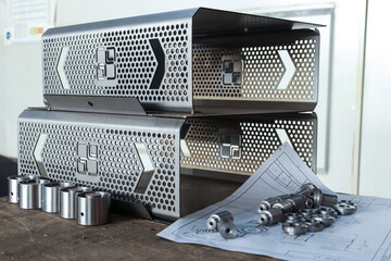 Parts cut by a plasma machine and turned on a lathe are on the table with drawings. Products manufactured at a metalworking plant. 