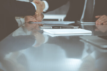 Business people shaking hands after contract signing in modern office. Teamwork and handshake concept