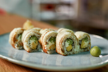 Closeup shot of sushi rolls ready for eating served on plate in a restaurant