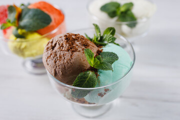 Ice-cream scoops variety in glass sundae bowls, refreshing dessert for summertime. Fruit sorbet, tasty treats