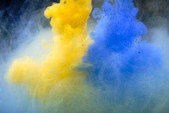 Fluid art. Abstract background. Yellow-blue flow on black.